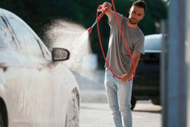 Otomobili yıkıyorum. Adam dışarıda arabasıyla bekliyor..