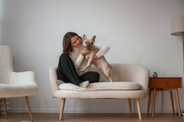 Birlikte oturuyoruz. Genç kadın köpeğiyle evde..