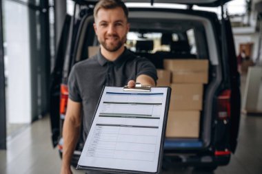 Not defterindeki siparişi doğrula. Teslimatçı ya da yükleyici arabanın yanında. 