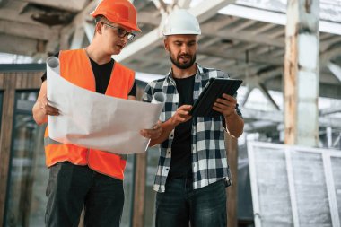 Binanın planı, mimari. İki işçi endüstriyel ahşap depoda..