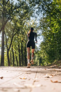 Düşük görüş, koşu, koşu. Genç, sıska kadın dışarıda siyah spor kıyafetleri giyiyor..