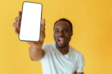 Boş akıllı telefon ekranı, beklemede. Siyah adam sarı arka planda stüdyoda..