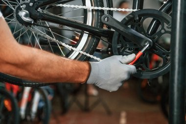 Raydan çıkarma sorunu, tamir. Bisikleti tamir eden adamın ellerine yakından bakın..