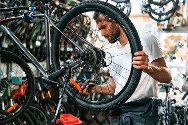 İşine odaklan. Bisiklet dükkanında tamirci, mağazada çalışıyor..