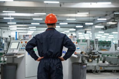 Dikiz ayarı, ayakta. Fabrika işçisi kasketli bir şekilde içeride..