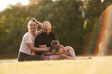 Erkek ve kadın sahada köpekle birlikteler..