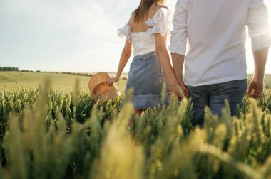 Arkadan bakın, el ele tutuşun, yürüyün. Güzel bir çift yeşil tarlada birlikte..