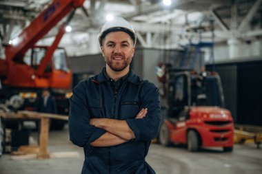 Ön manzara, ayakta. Erkek işçi, modern depo veya imalat şirketinde çalışıyor..