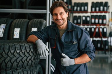 Olumlu yüz ifadesi. Lastik tamir servisinde adam var..