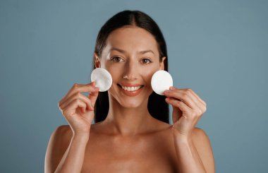 Kaldırmak için makyaj yap. Genç kadın stüdyoda arka planda..