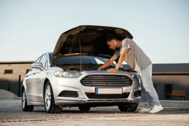 Bozuk otomobili tamir etmeye çalışıyorum. Adam dışarıda arabasıyla bekliyor..