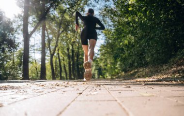 Düşük görüş, koşu, koşu. Genç, sıska kadın dışarıda siyah spor kıyafetleri giyiyor..