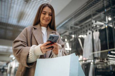 Aşağıdan bak, akıllı telefonla. Alışveriş merkezinde güzel bir kadın var, alışveriş anlayışı..