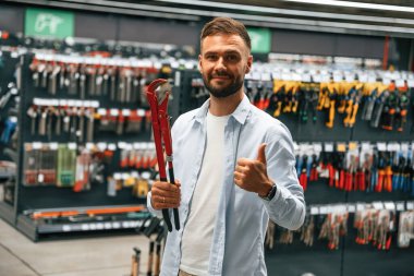 Kırmızı boru anahtarı. Adam hırdavatçıda..