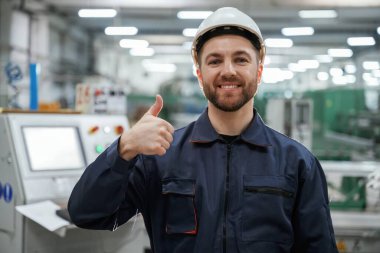 Başparmağımı gösteriyorum. Fabrika işçisi kasketli bir şekilde içeride..