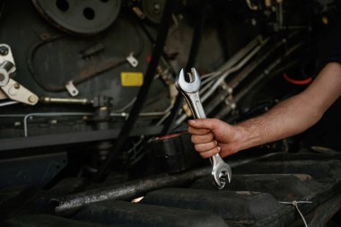 Manzarayı kapat. Tamircinin el tamircisi atölyede ingiliz anahtarıyla makineyi tamir ediyor..