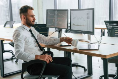 İşadamı bilgisayar başında oturuyor ve ofiste çalışıyor..