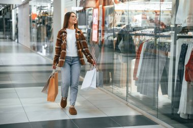 Koridorda, camın yanında. Kadın süpermarkette alışveriş yapıyor..