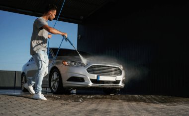 Araba yıkama servisi, adam dışarıda arabasıyla bekliyor..