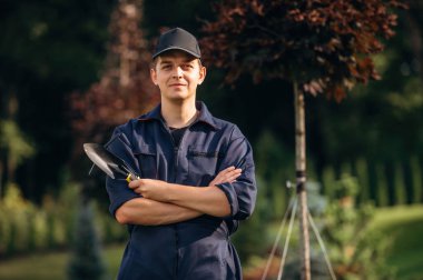 Kollarını kavuşturmuş duruyorsun. Bahçede profesyonel bahçıvan var..