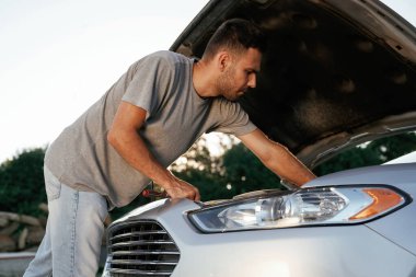 Bozuldu, kaput açıldı, tamir ediliyor. Adam dışarıda arabasıyla bekliyor..