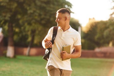 Sırt çantasıyla. Genç erkek öğrenci dışarıda..