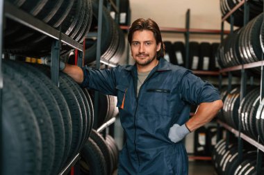 Profesyonel üniformalı. Lastik tamir servisinde adam var..