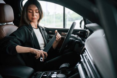 İçerisi rahattır. Güzel iş kadını yeni arabasında..