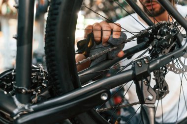 Arka tekerlek ayarlaması. Bisiklet dükkanında tamirci, mağazada çalışıyor..