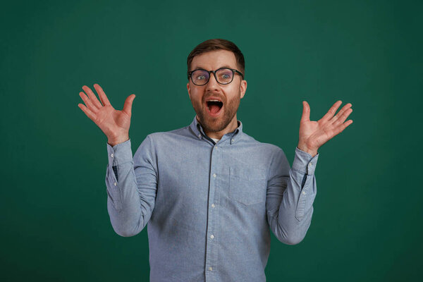 Shocked facial expression. Man is standing against background in the studio.