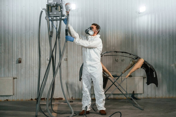 Металлическая туша. Ремонтник работает в гараже.