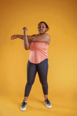 Eller için alıştırmaları ısıt. Afrikalı Amerikalı kadın sarı arka planda stüdyoda..