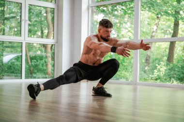 Yoga esneme hareketleri. Güçlü kaslı adam spor salonunda çalışıyor..