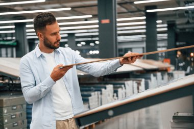 Farklı renkte parke. Adam hırdavatçıda..