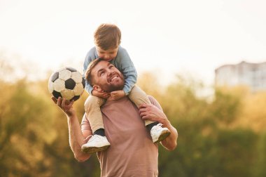 Gerçek futbol, futbol topu. Mutlu baba ve oğul yazın sahada eğleniyorlar..