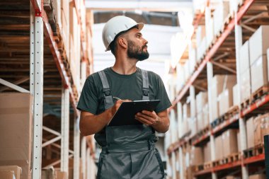 Not defteriyle kalite kontrol. Foreman depoda, kargo dağıtım işinde..