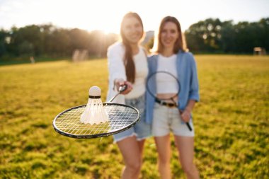 Shuttlecock badminton raketinde. İki kadın sahada eğleniyor..