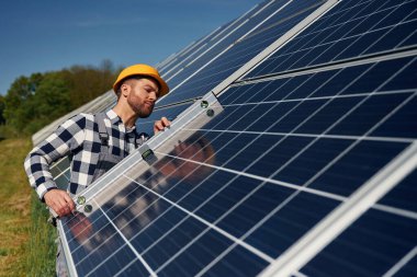 Dengeleyiciyi kullanarak. Gündüz vakti fotovoltaik güneş panelleri olan bir mühendis..