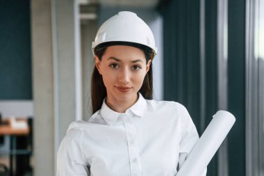 Kasketli ve beyaz elbiseli kadın mimar portresi..