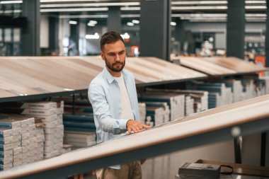 Büyük parke seçimi olan bir depo. Adam hırdavatçıda..