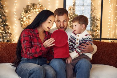 Hediye kutusunu açıyorum. Mutlu bir aile yeni yılı evde kutluyor..