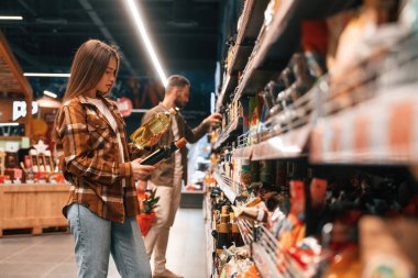 Ellerinde yağ var. Genç çift süpermarkette beraberler..