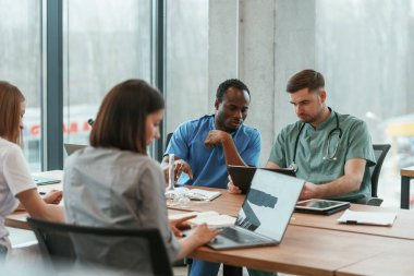 Masanın yanında. Bir grup doktor içeride birlikteler..