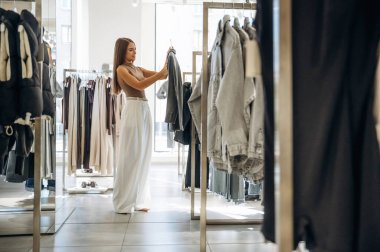 Modern moda kıyafeti. Kadın mağazadan kıyafet seçiyor..