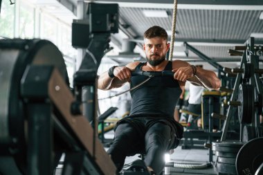 Dayanıklılık egzersizi. Güçlü kaslı adam spor salonunda çalışıyor..