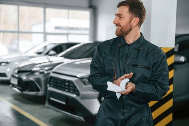 Elleri siliyorum. Tamirci garajda arabalarla bekliyor..