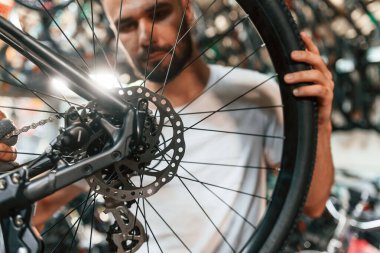 Arka tekerlek ayarlaması. Bisiklet dükkanında tamirci, mağazada çalışıyor..
