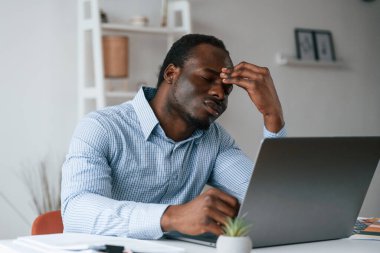 Kötü ve stresli hissediyorum. İşadamı ofiste bilgisayarla çalışıyor..