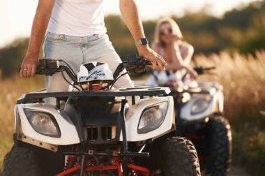 Kırsal yol, ön manzara. Erkek ve kadın dışarıda ATV 'deler..