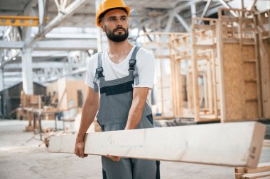 Ön manzara, kalas tutuyor. Ahşap depoda sanayi işçisi..